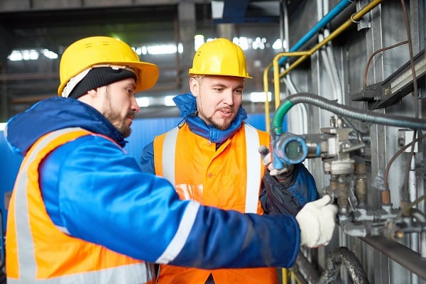 Opérateurs de centrale ajustant une vanne de contrôle